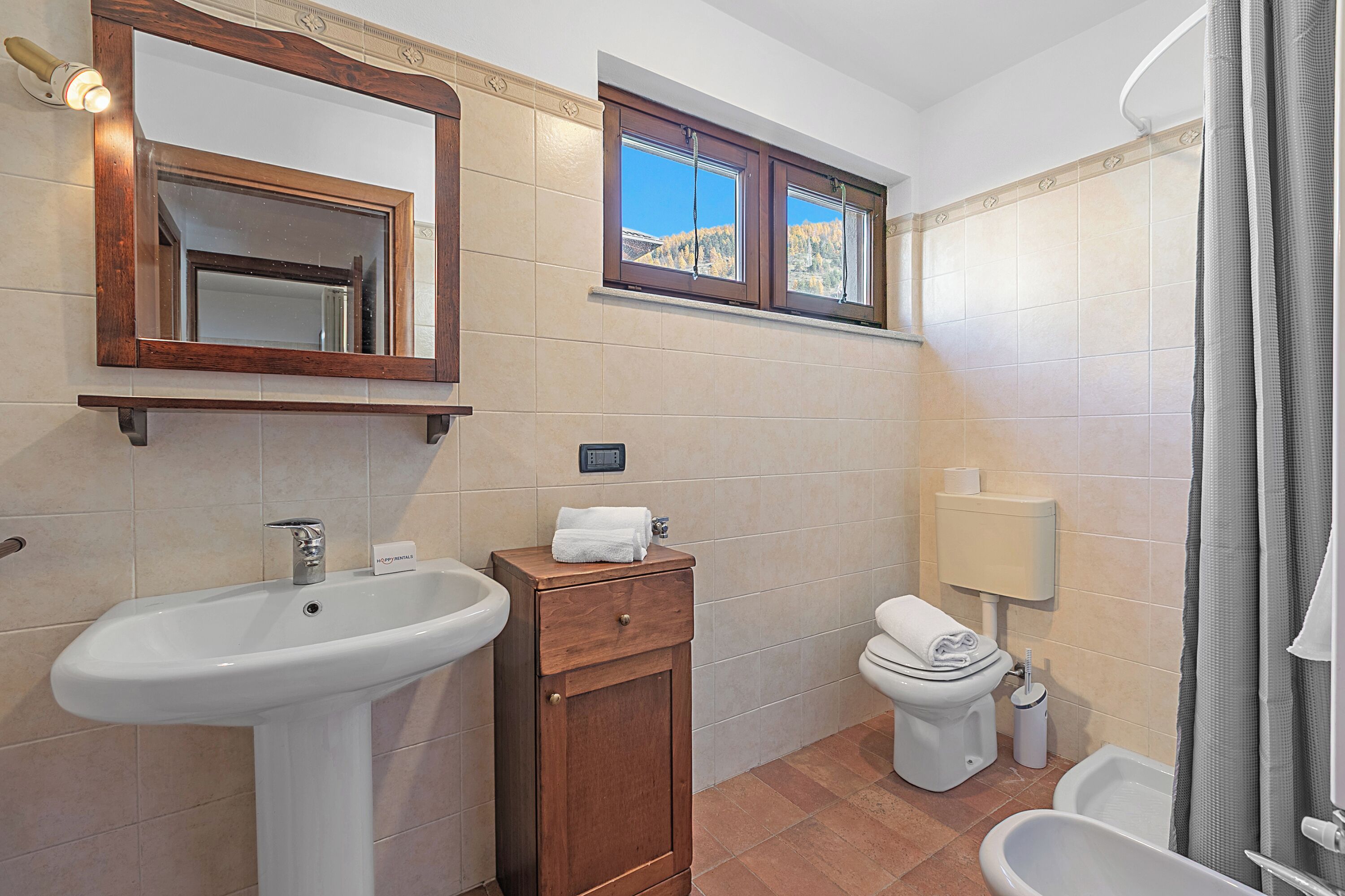 A bathroom with a sink, mirror, toilet, and bathtub.