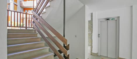 A staircase with wooden handrails leading to an upper floor.