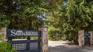 A sign with the word "Sundance" indicating the entrance to a property surrounded by trees.
