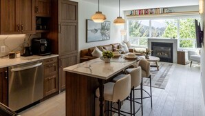 A modern kitchen with a central island, wooden cabinets, and a fireplace.