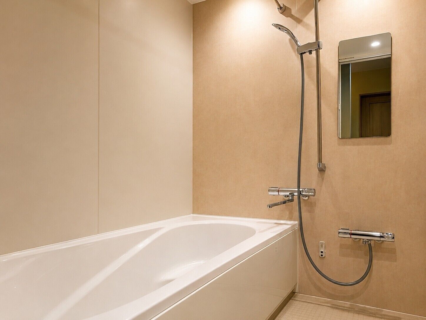 Un baño moderno con bañera, ducha y espejo.