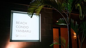 A signboard for 'Beach Condo Yanbaru' with a logo. - Yanbaru Pool Condo Yagaji by COLDIO (Nago)