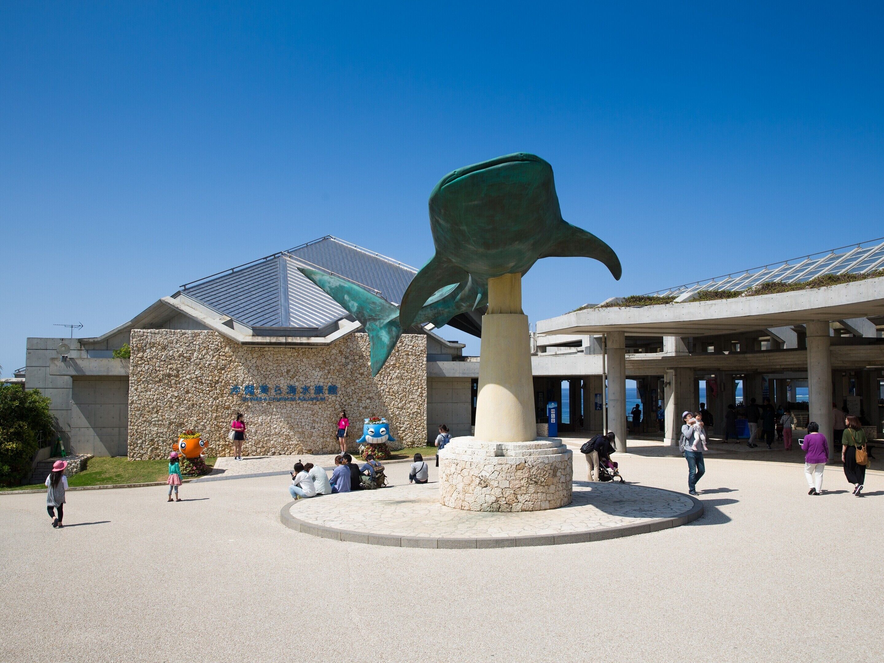 A building with a stone facade and a large sculpture of a fish.