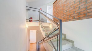A staircase with glass railings and a brick wall. - The Blue House With Sauna & Jacuzzi (Desinic)