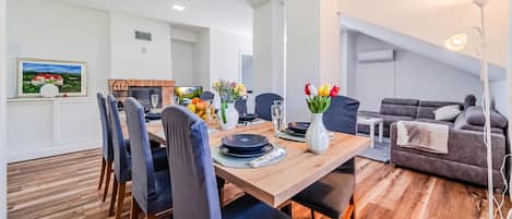 Una sala de estar moderna con comedor, chimenea y sofá.