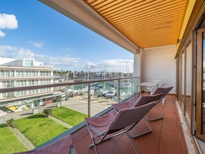 Ein Balkon mit Blick auf eine Marina, eine Rasenfläche und ein mehrstöckiges Gebäude.