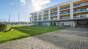 En modern byggnad med flera våningar, ett platt tak, stora fönster och balkonger.