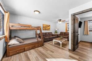 A compact living space with a bunk bed, two sofas, a coffee table, and a ceiling fan. - Walk to Dining, 1 Mile to SDC, Campfire Pit, Cornhole! (Branson)