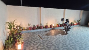 A tiled patio area with potted plants and a motorcycle.