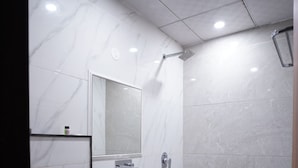 A modern bathroom with a white toilet, a white sink, and a shower area. - THE SPARK INN (Jaipur)