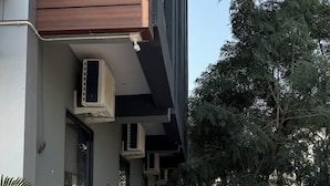 A building with a checkered floor, air conditioning units, and red pipes. - THE SPARK INN (Jaipur)