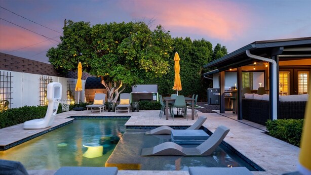 A modern outdoor pool area with lounge chairs, a barbecue, and a covered seating area. - Elevated Old Town Scottsdale Pool| Spa| Sauna|Gym (Scottsdale)