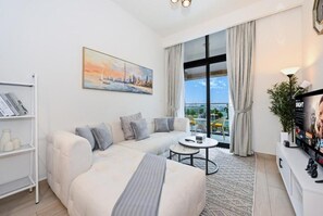 Ein modernes Wohnzimmer mit einer Couch, einem Couchtisch und einem Fernseher auf einem Lowboard.