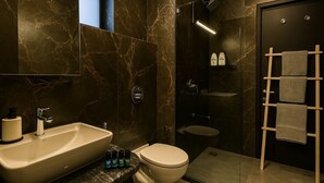 Ein modernes Badezimmer mit einem großen Waschbecken, Toilette und Duschbereich.