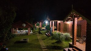 Ein Innenhof mit Backsteingebäuden, einem gepflasterten Weg und Außenplätzen.