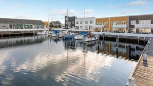 A marina with boats docked, wooden walkways, and buildings with various architectural styles. - "Fina" - 10m from the sea by Interhome (Ebeltoft)