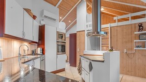 Eine moderne Küche mit Granit-Arbeitsplatten, Edelstahlgeräten und Holzelementen.