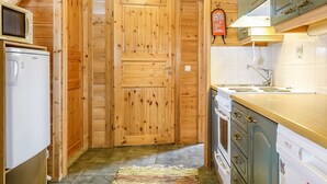 A compact kitchen with wooden cabinets, a built-in oven, a microwave, and a sink.