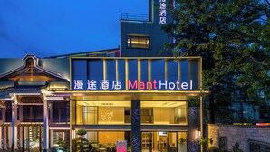 A hotel with a modern facade, signage in both English and Chinese, and a well-lit entrance. - Mant International Hotel Ancient Whampoa Anchorage Scenic Spot Canton Fair Complex Branch (Guangzhou)