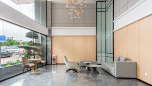 A modern lobby with a seating area, a large window, and a unique chandelier. - Mant International Hotel Ancient Whampoa Anchorage Scenic Spot Canton Fair Complex Branch (Guangzhou)