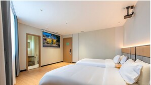 A hotel room with a large bed, a wooden floor, a view of a cityscape, and a door leading to a bathroom. - Mant International Hotel Ancient Whampoa Anchorage Scenic Spot Canton Fair Complex Branch (Guangzhou)