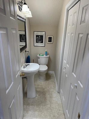 A narrow bathroom with a pedestal sink, a toilet, and framed animal prints on the wall. - Serene Lake Hartwell Escape with Private Dock & Stunning Views (Hartwell)