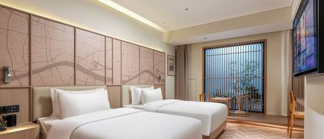 A hotel room with two beds, a desk with a phone, a TV, and a large window with a view of greenery.