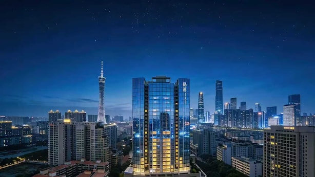 A high-rise hotel with a modern glass facade, surrounded by other tall buildings in a cityscape at night. - PIN Hotel Guangzhou Beijing Road Pedestrian Street Peasant Movement Institute Metro Station Branch (Guangzhou)