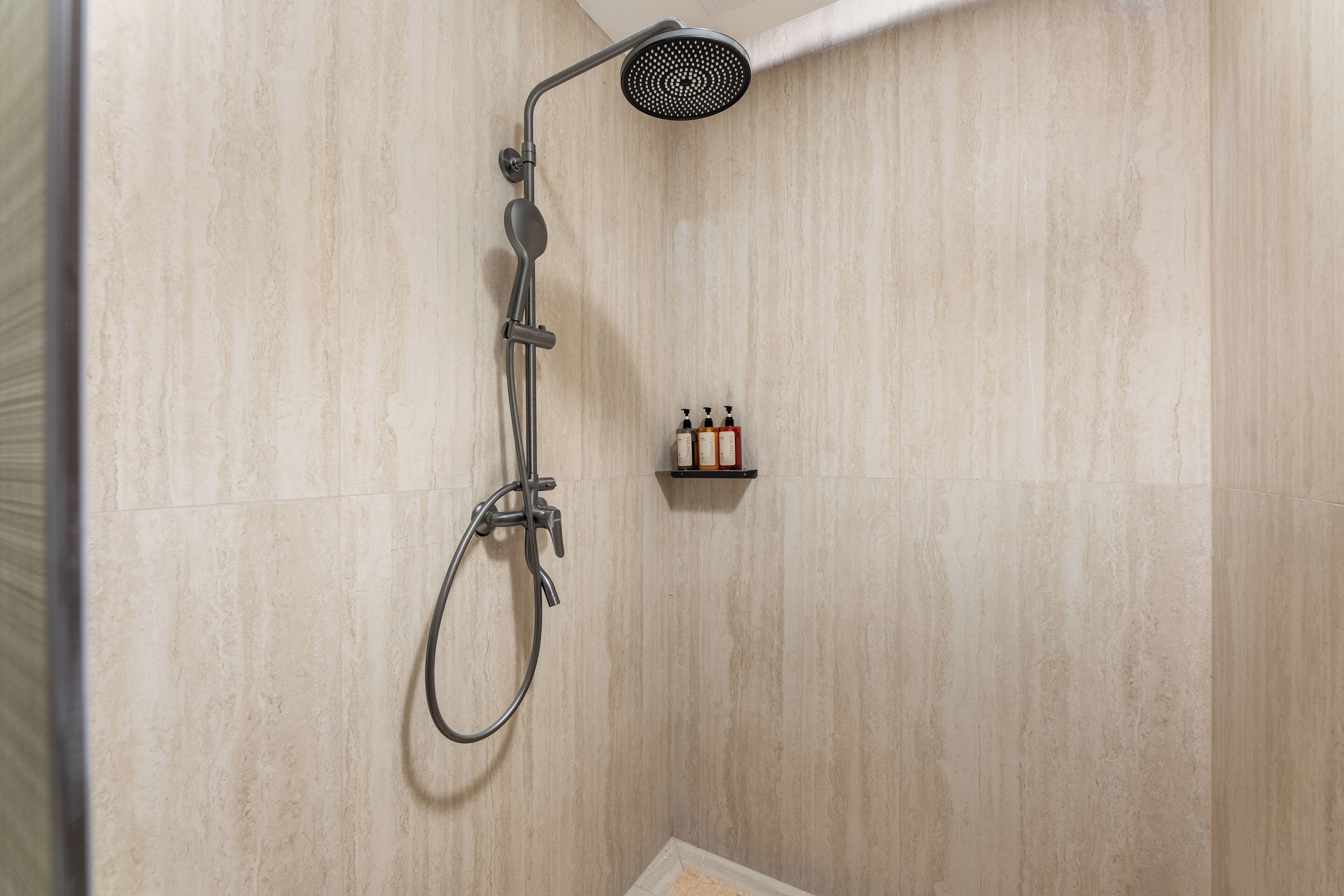 A shower with a handheld showerhead and a handheld faucet.