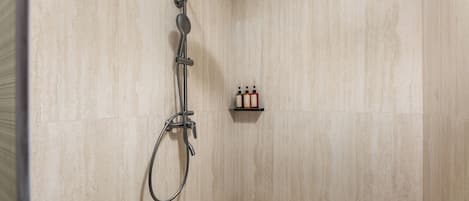 A shower with a handheld showerhead and a handheld faucet.