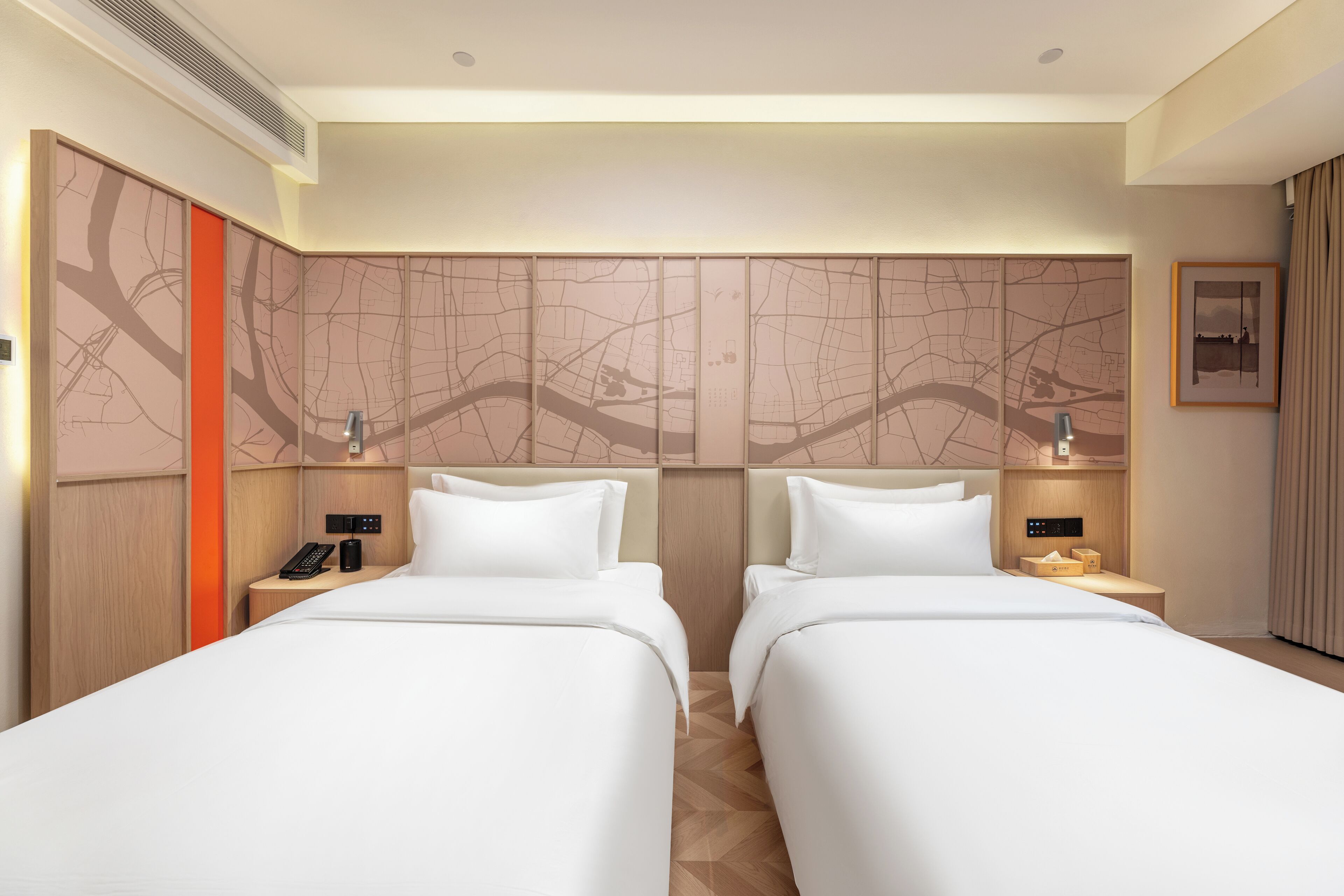 Quarto de hotel com duas camas, parede com mapa, telefone e mesa de cabeceira.