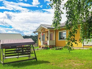 A yellow house with a porch, a covered area, and a grassy yard. - Murtolampi by Interhome (Rautalampi)