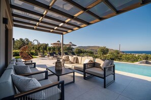 Ein überdachter Außenbereich mit Pool, mit Blick auf eine malerische Landschaft.