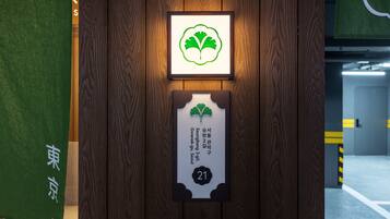 A wooden wall with a framed green leaf symbol and a sign indicating room number 21.