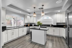 Fully equipped gourmet kitchen with white cabinetry, sleek granite counters and stainless-steel appliances. Center island with bar seating and pendant lighting makes cooking and socializing a delight. - Luxury Home w/ Heated Pool, Hot Tub  & Professional Private Movie Theater (Las Vegas)