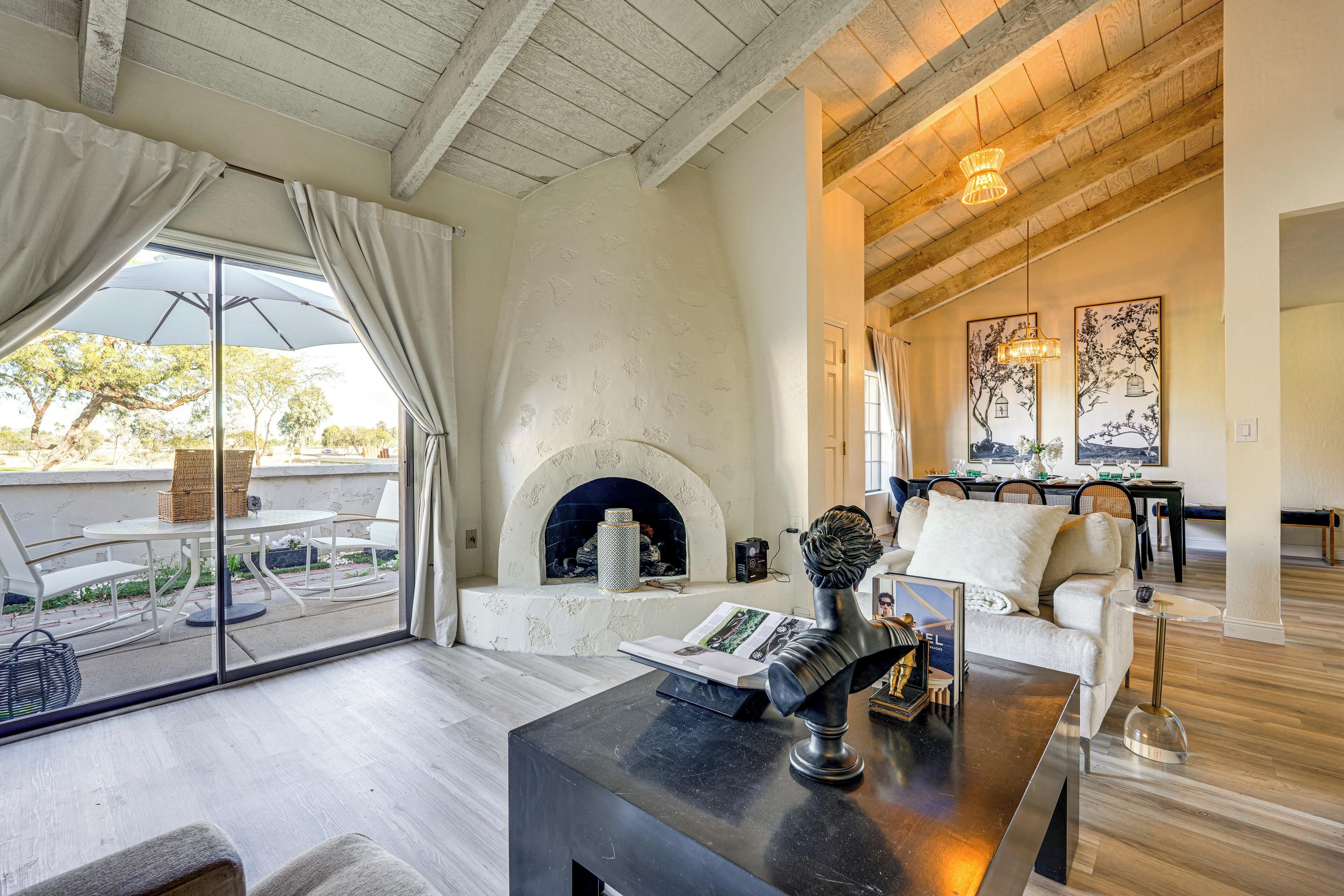 Un vaste salon doté d’une cheminée, d’un coin repas et d’un balcon aménagé avec du mobilier d’extérieur.