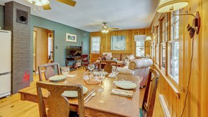 Un interior de madera con una mesa de comedor para cuatro personas, un sofá y una chimenea.