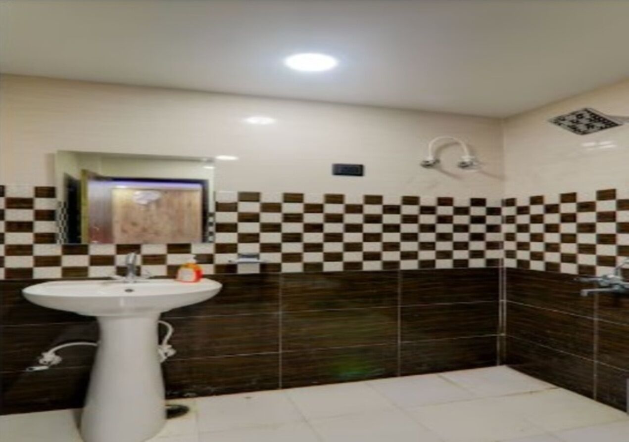 A bathroom with a white sink, a mirror, and checkered tiles on the walls.