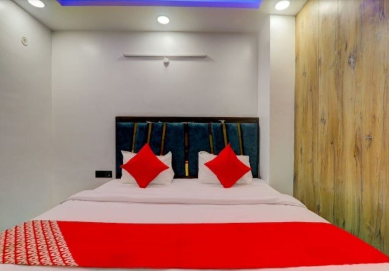 Un dormitorio con cama, armario de madera y una lámpara en el techo.