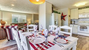 A dining area with a table set for four, white chairs, and a red and white table runner. - Stunning SLC Basecamp: Ski, Explore & Unwind (Salt Lake City)