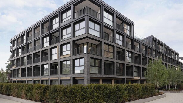A modern multi-story building with balconies, large windows, and a well-maintained hedge in front. - Comfortable Studio near Arena | Parking in Garage (Kraków)