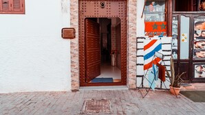 Una puerta con una celosía metálica y una pequeña ventana encima.