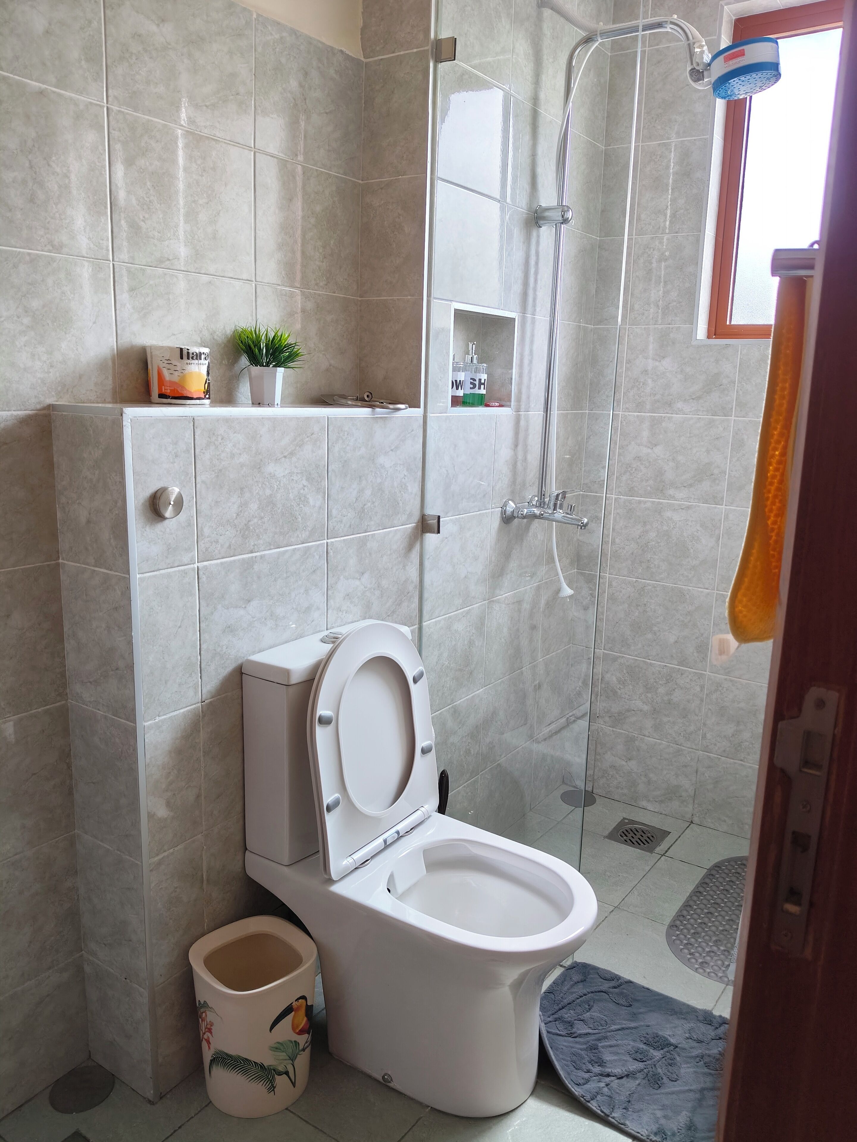 Een douche, handdoeken, zeep, toiletpapier
