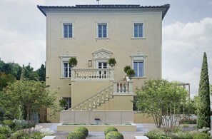 A two-story building with a symmetrical facade, a central balcony with balustrades, and a staircase leading to the entrance. - Villa in Legoli with 5 bedrooms sleeps 10 (Legoli)