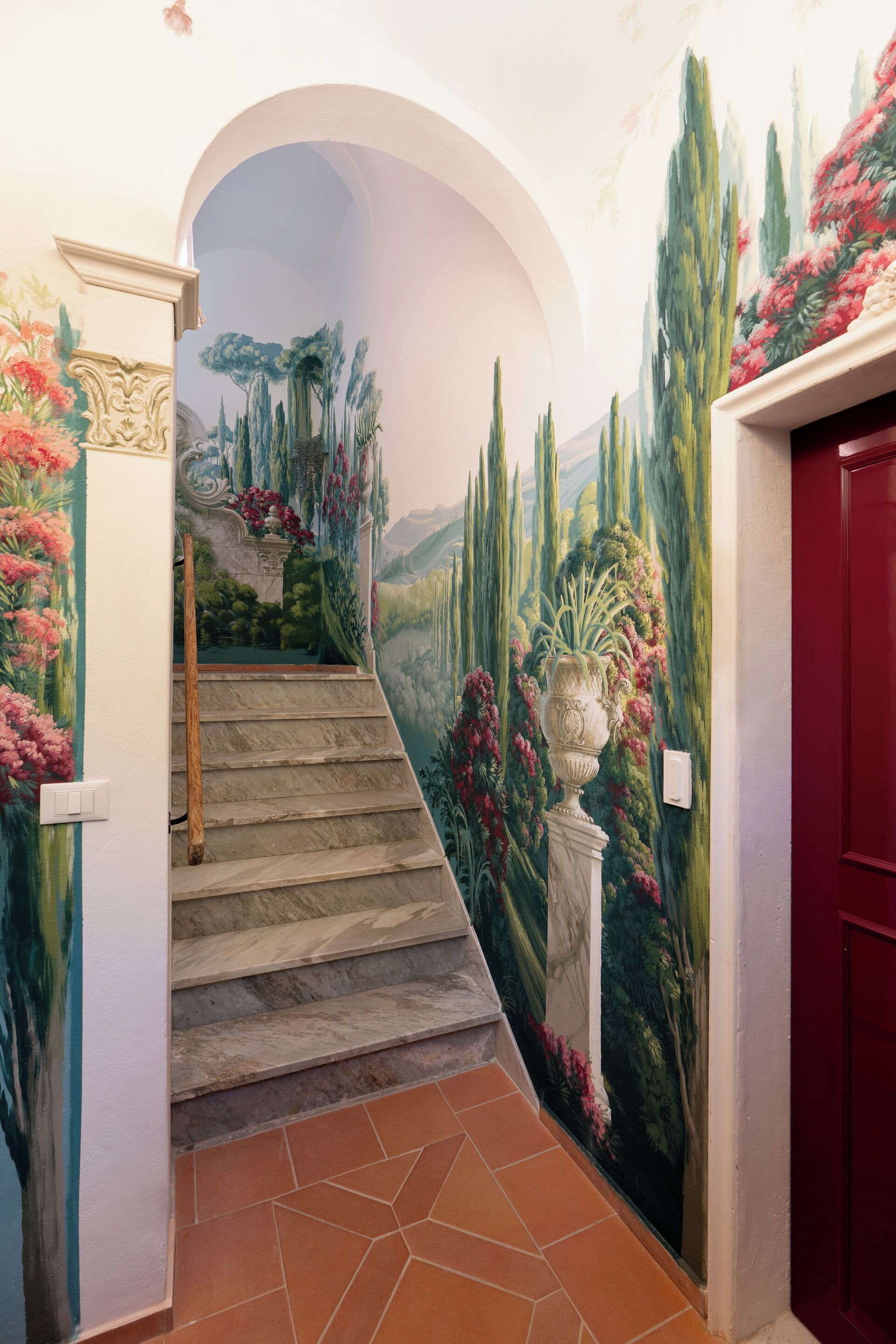 A staircase leading to a room with a mural of a landscape.