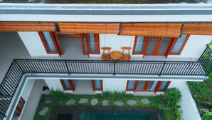 Un bâtiment à deux étages doté d’un balcon, d’une piscine et d’un jardin.