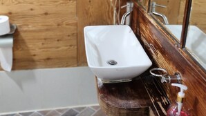 A bathroom with a wooden vanity, a white sink, and a mirror. - Shim Stay (Anyang)