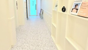 A hallway with a speckled floor, white walls, and a door labeled "NINTH". - Shim Stay (Anyang)