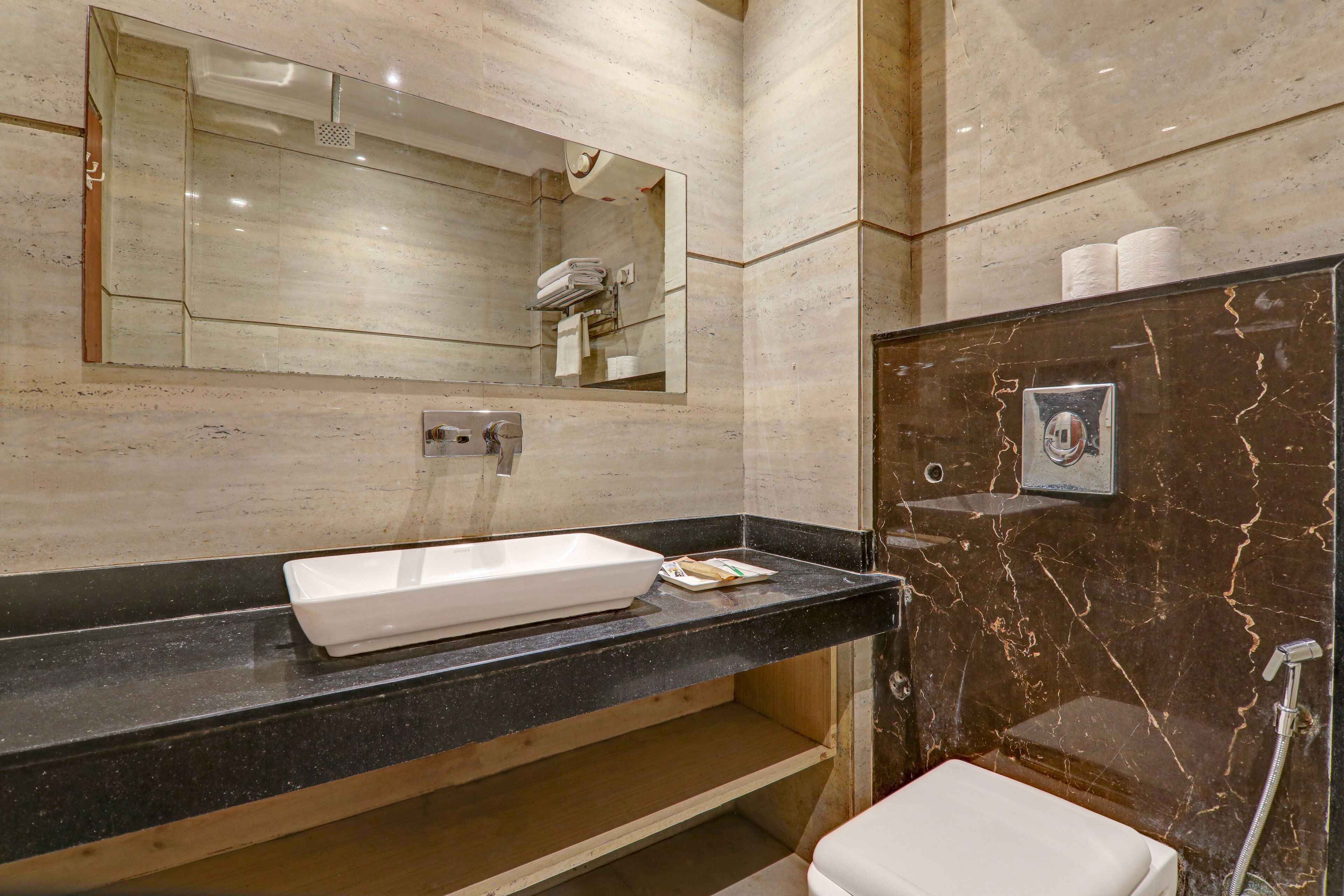 Un baño moderno con un espejo grande, un lavabo blanco y una zona de ducha.