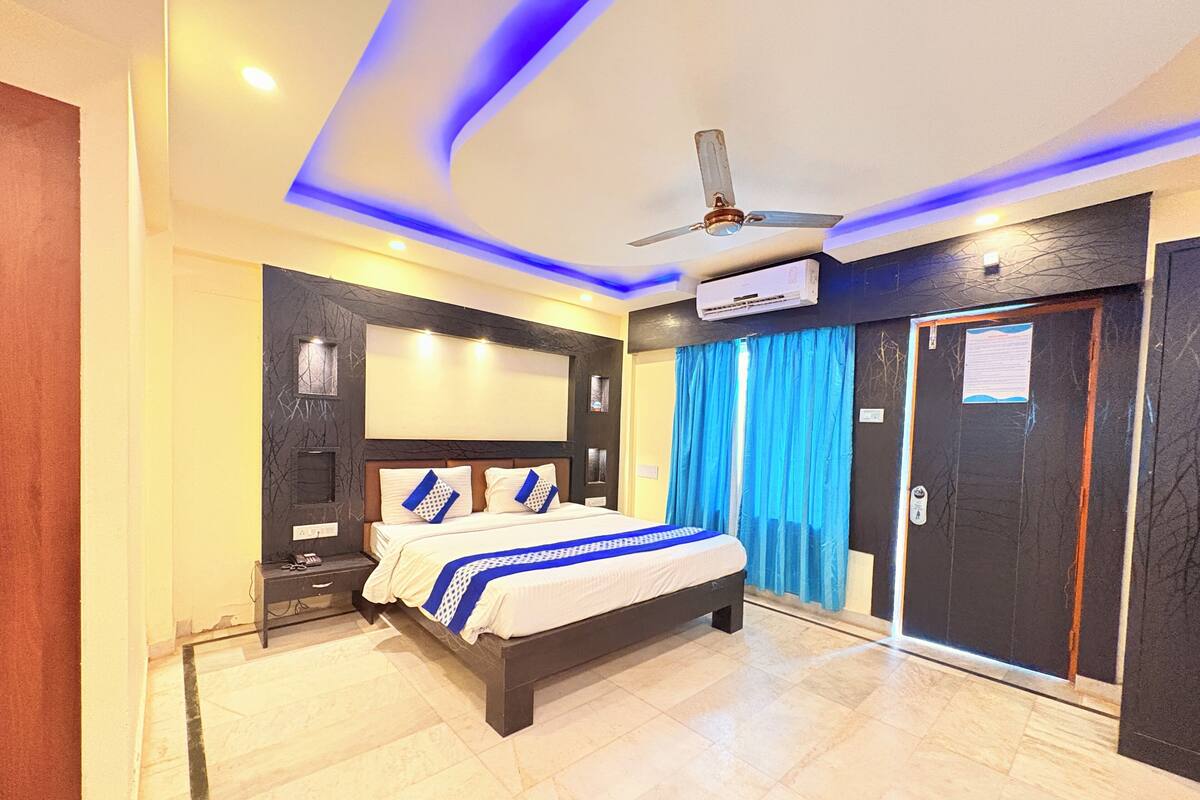 Een moderne slaapkamer met een groot bed, een plafondventilator en een airconditioning.